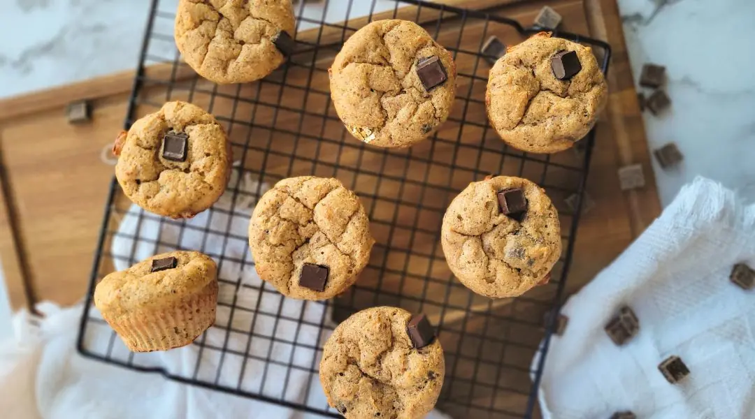 Soft chocolate chip muffins cooling on a black wire rack