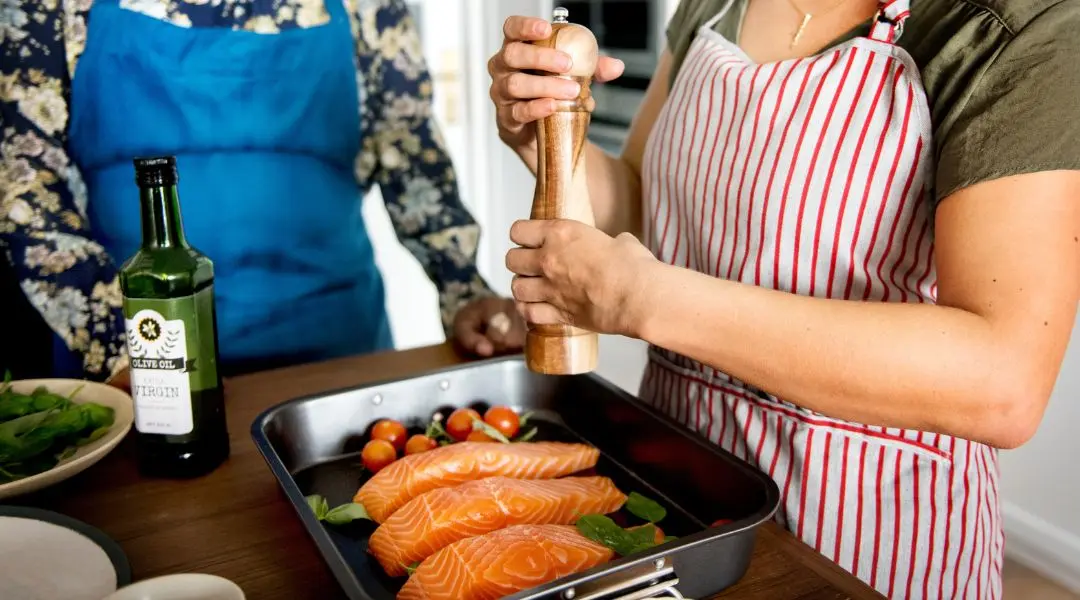 Preparing salmon fillets with olive oil and seasoning.