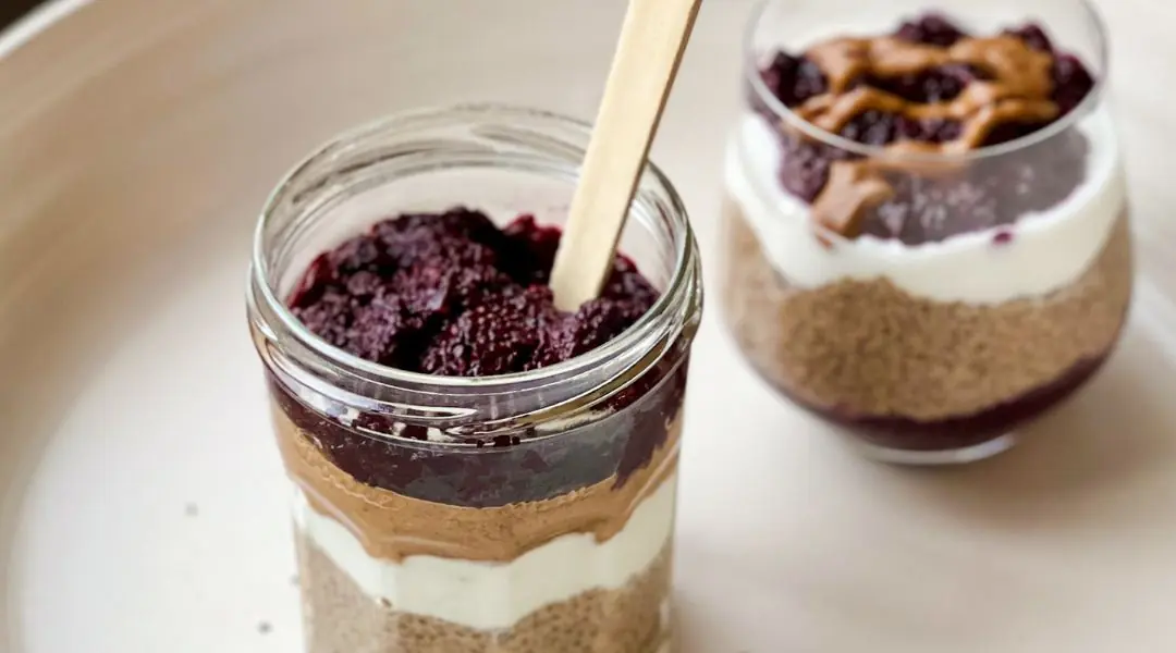 Layered chia pudding with yogurt, peanut butter, and berry spread