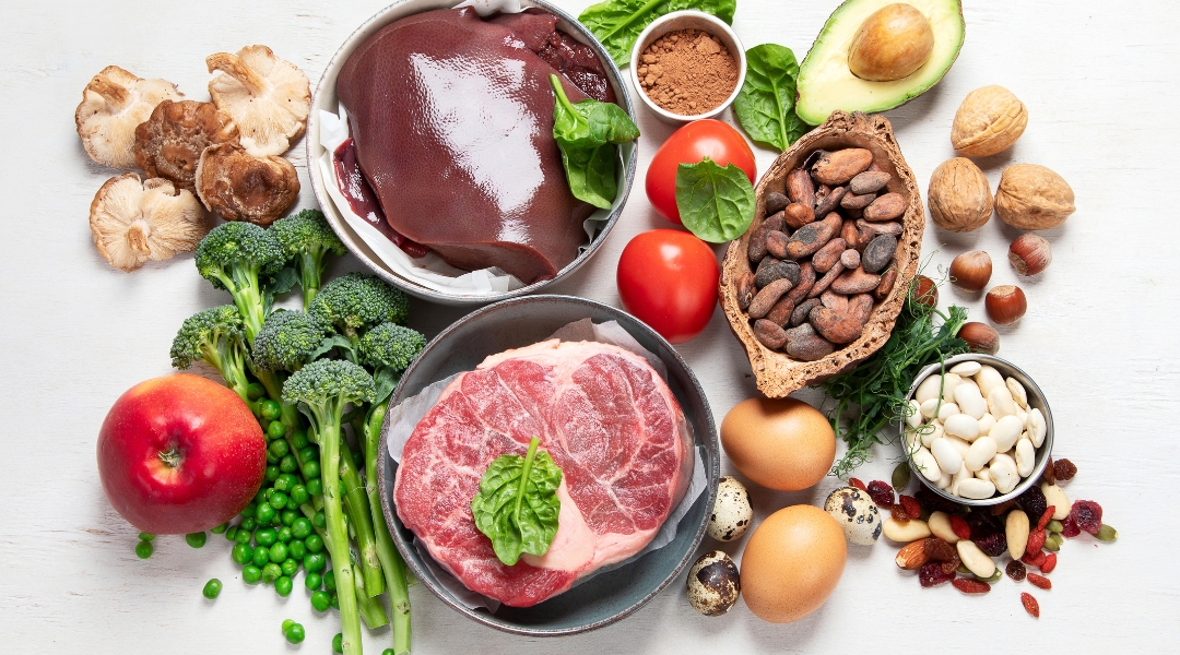 an assortment of foods including meat, vegetables and nuts rich in iron