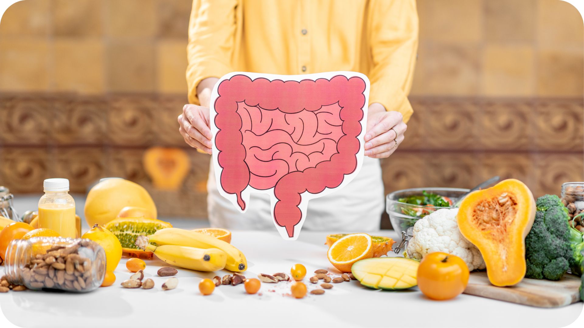 Dietitian holding an illustration of the digestive system surrounded by gut-healthy foods