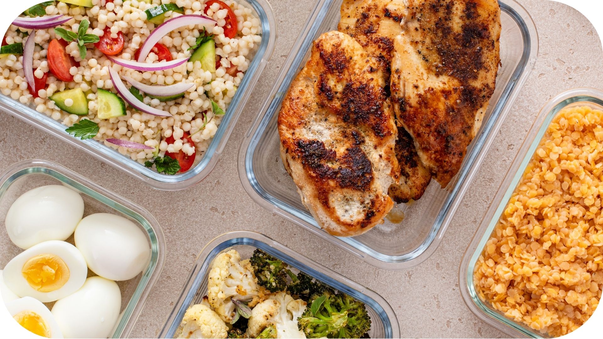 Meal featuring grilled chicken, a couscous salad, hard-boiled eggs, roasted vegetables, and lentils