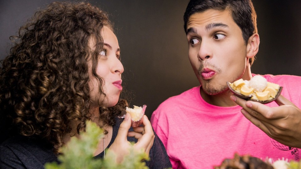 man and woman eating while looking at each other