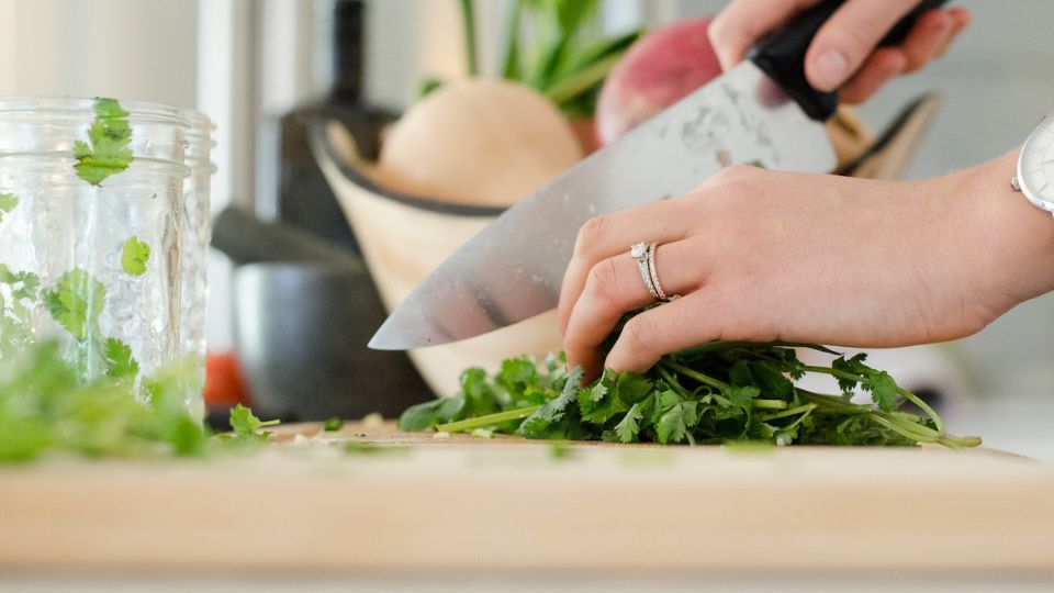 woman cutting parsley with chef's knife