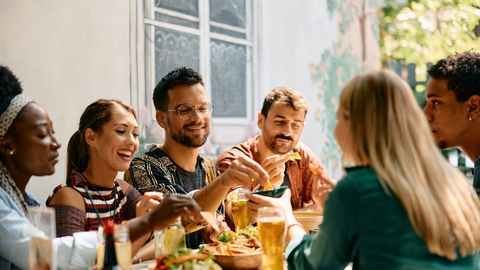 A group of friends enjoying a meal together at Nepan, Ottawa, sharing food and drinks in a casual, social setting.