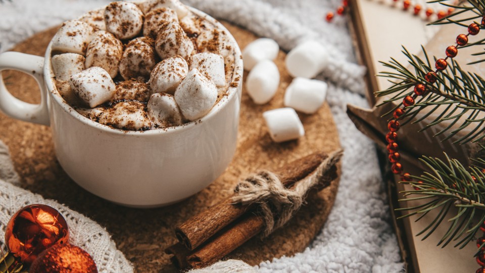 hot chocolate with marshmallows on a table decorated for Christmas