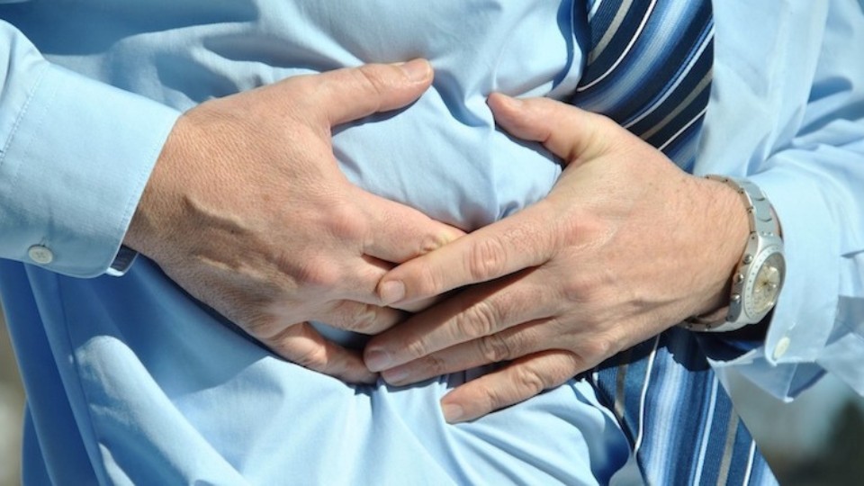 Man with a blue shirt having abdominal pain