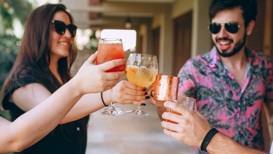 women and men in summer with a cocktail in their hands