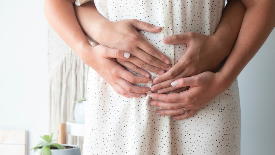 pregnant woman, nausea, hands on pregnant belly