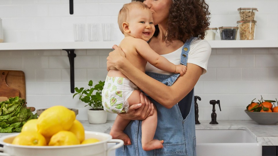 woman holding her baby in a kitchen
