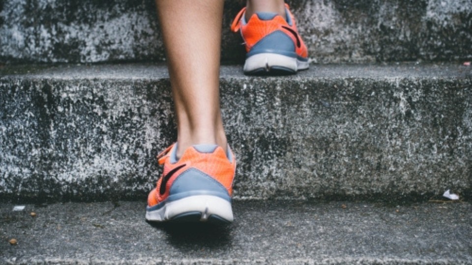 a person climbing the stairs in sports shoes