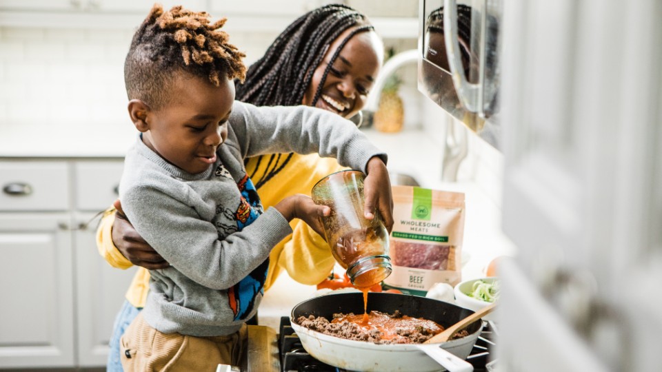 mother and son smiling and cooking