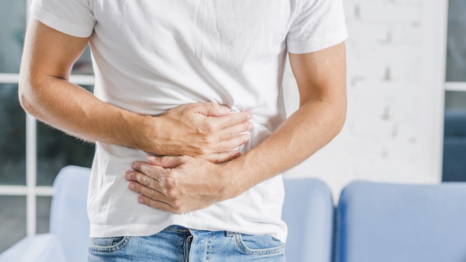 homme qui se tient le ventre à cause de diverticulites