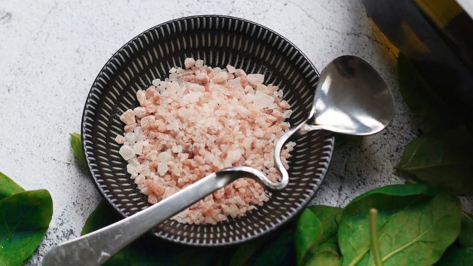 bowl of Himalayan salt with spinach on the side