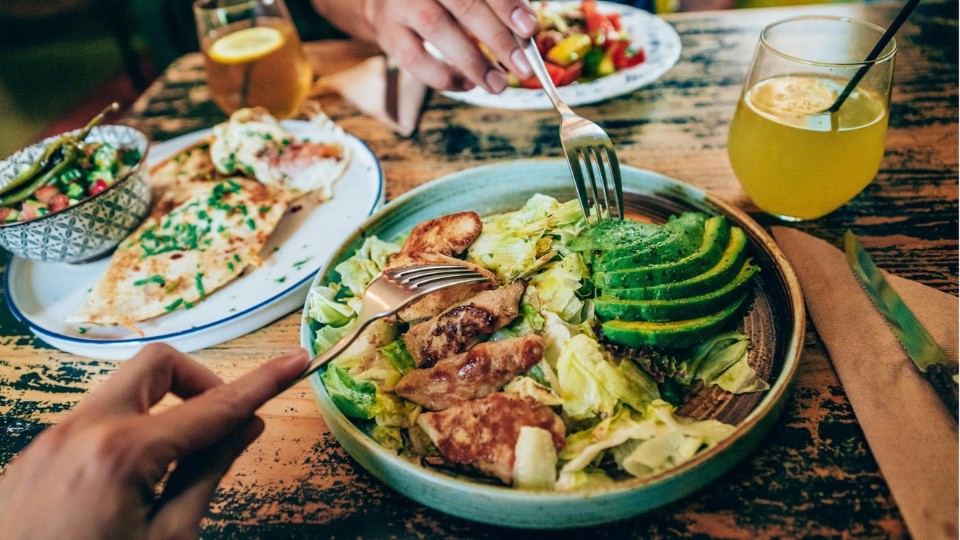 Chicken and avocado salad with forks digging in.