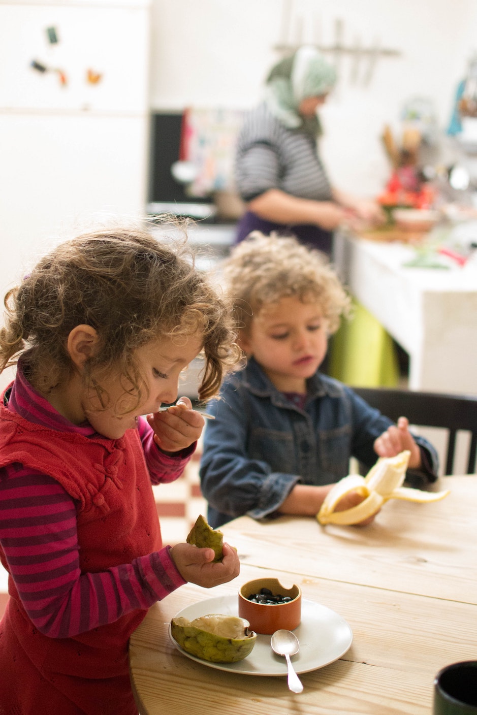 two little girls tasting fruit