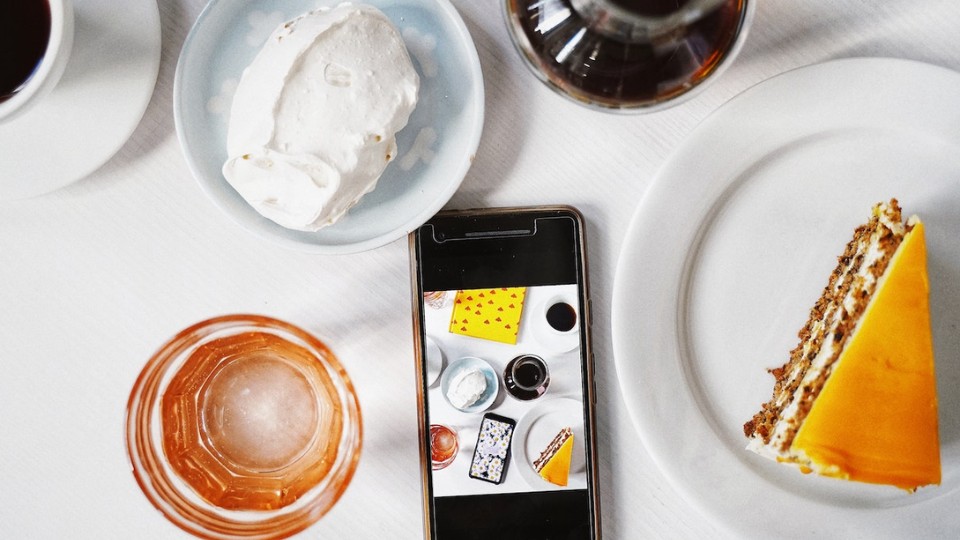 A cellphone  surrounded by food and drinks