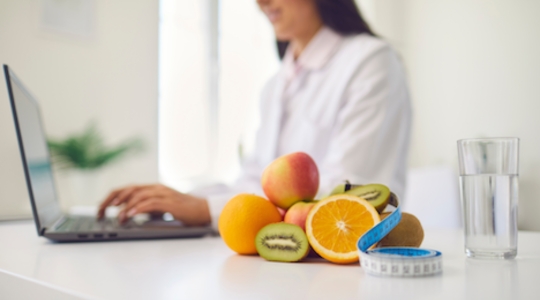 fruirs in the foreground and lady on a computer in the background