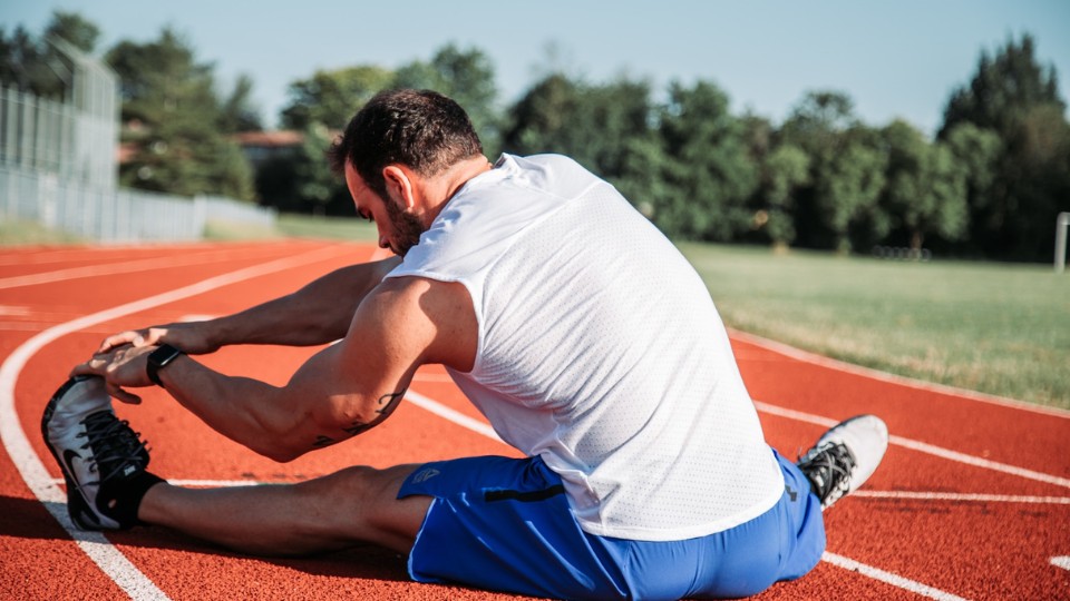 A person stretching on a racetrack