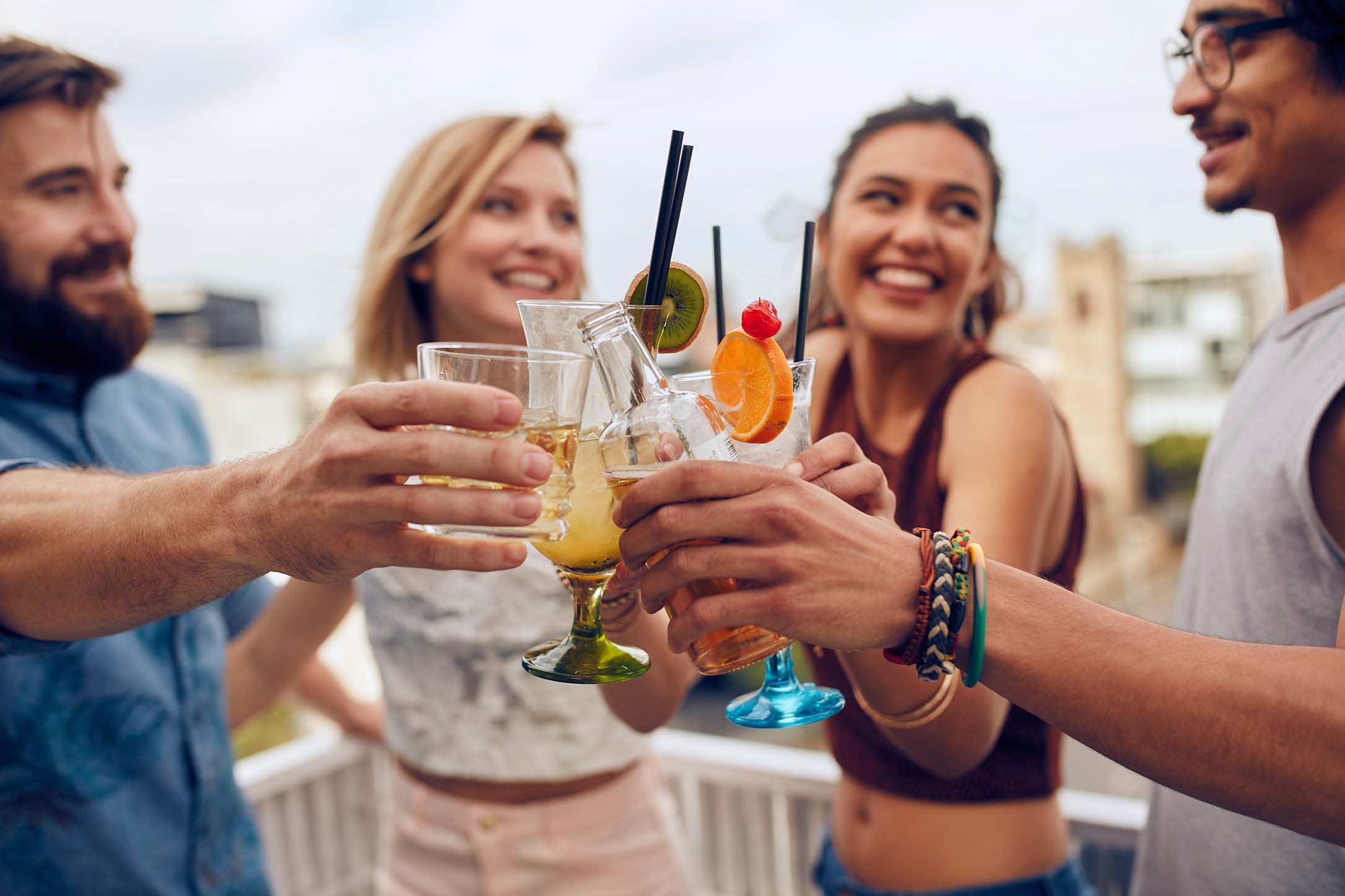 Des amis trinquent avec des cocktails lors d'une fête en plein air - Friends toasting with cocktails at an outdoor party