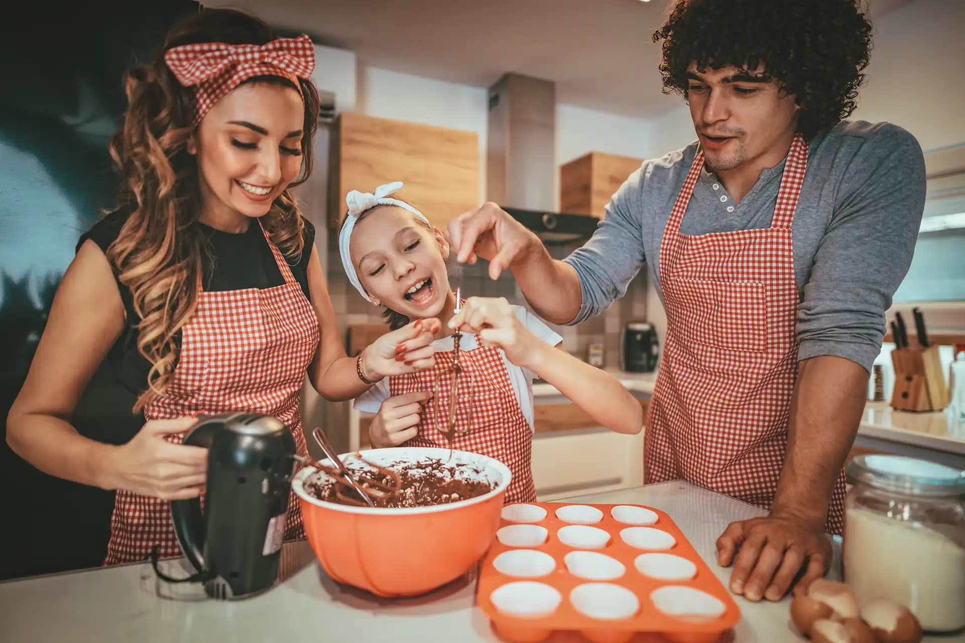 Famille souriante en train de cuisiner un dessert - Smiling family cooking a dessert together