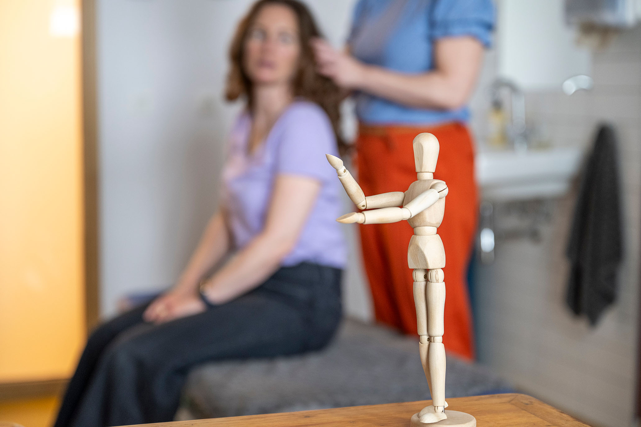 A wooden mannequin in focus on a table - Un mannequin en bois net sur une table