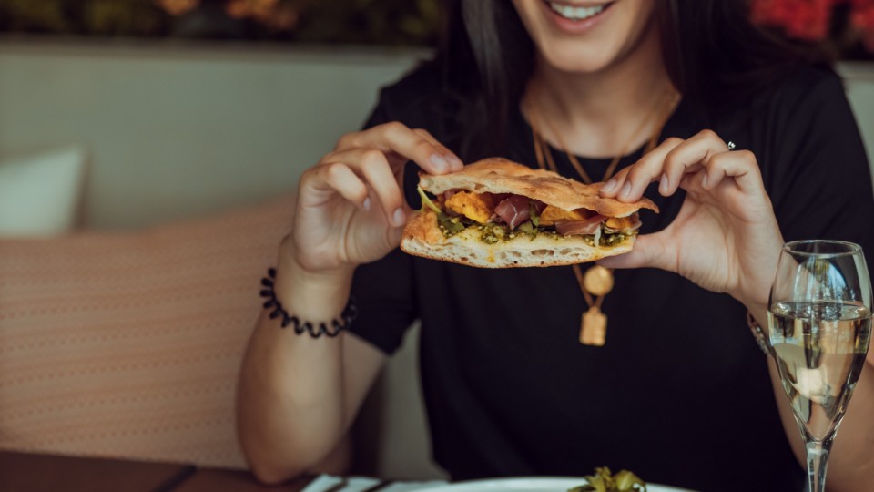 Woman eating mindfully her sandwich at a restaurant