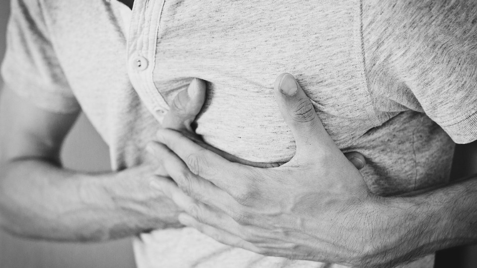 Man with hands on his chest because of acid reflux