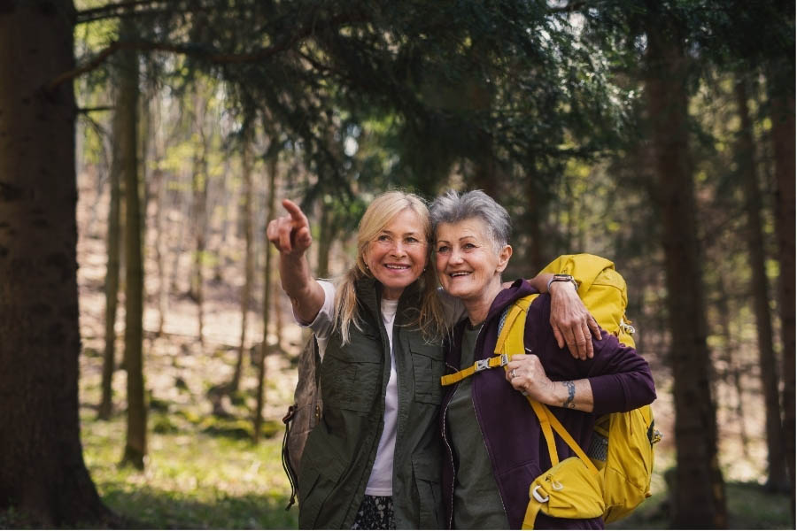 Two senior women enjoying a hike in the forest