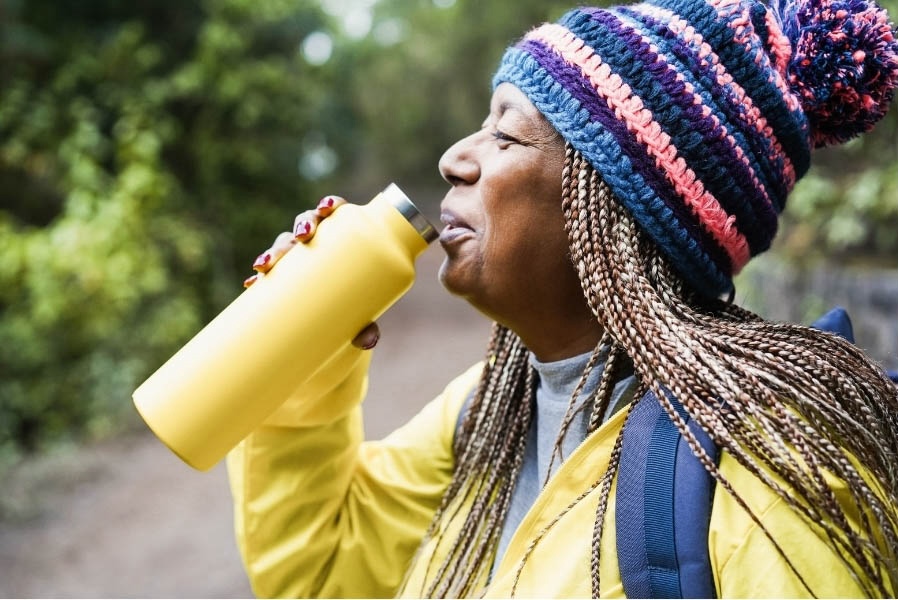 Woman drinking from a water bottle while hiking