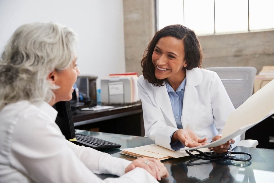 Doctor talking with a smiling elderly patient in an office