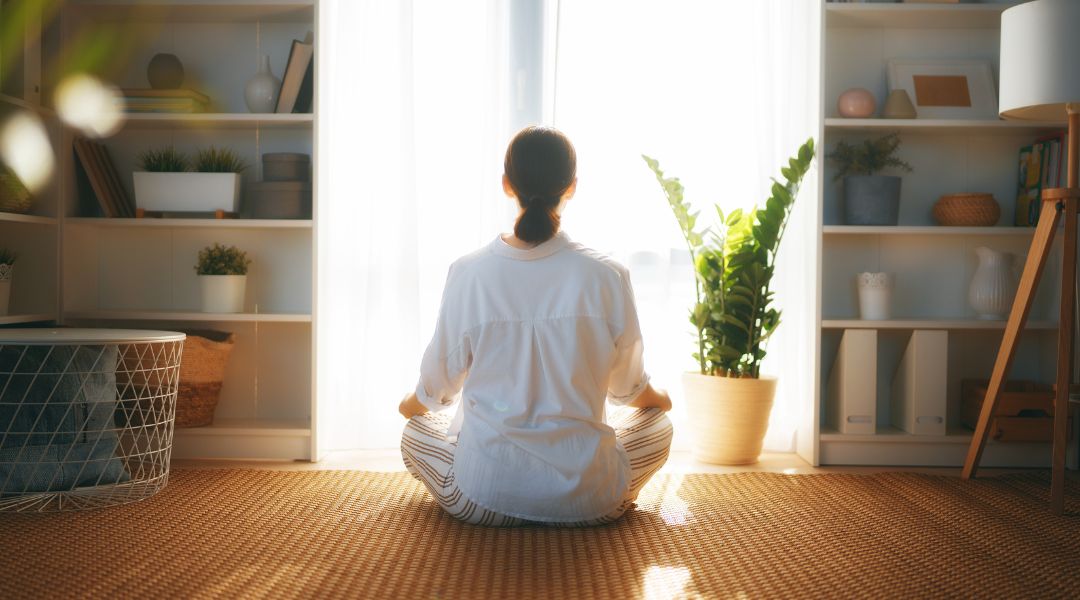 someone meditating in a cozy living room
