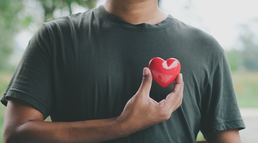 a man holding a plastic heart