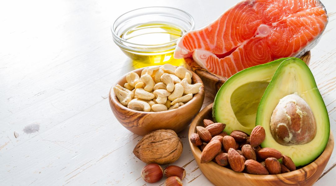 fish, nuts, avocado and olive oil on a wooden table