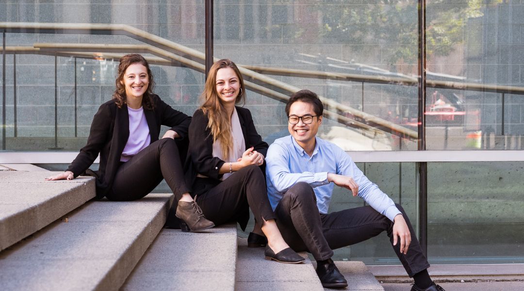 three business dietitians sitting on steps in front of a building