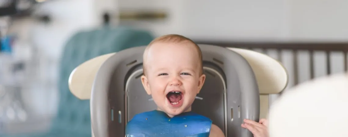smiling baby in highchair