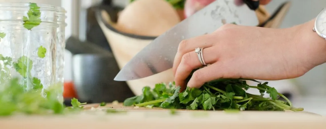 woman cutting parsley with chef's knife
