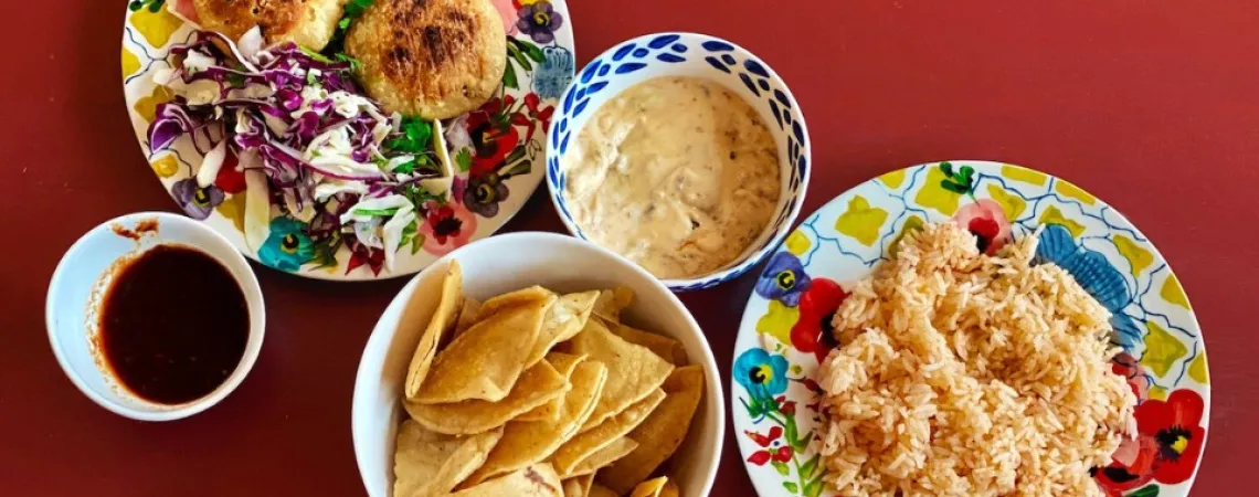 rice, patties and chips in dishes on a red background