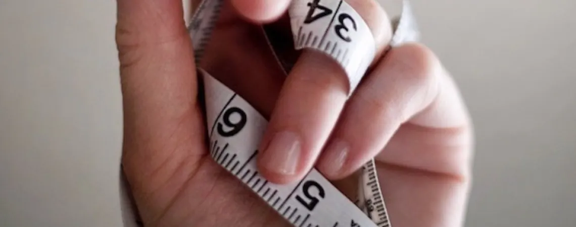 hand holding a body measuring tape