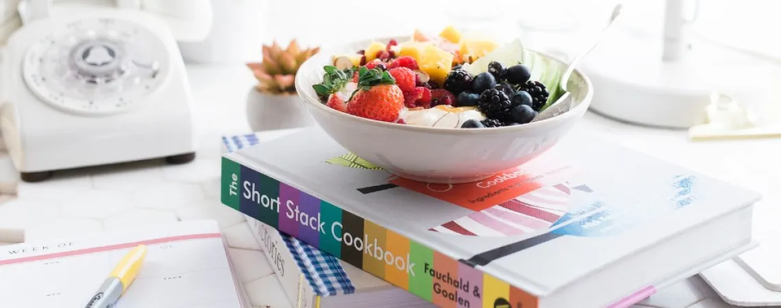 bowl of fruit on a pile of books