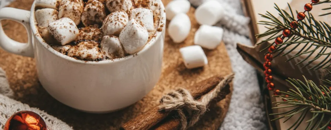 hot chocolate with marshmallows on a table decorated for Christmas