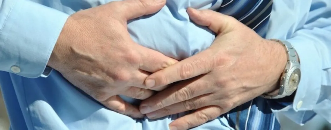Man with a blue shirt having abdominal pain