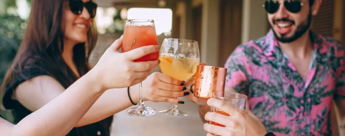 women and men in summer with a cocktail in their hands