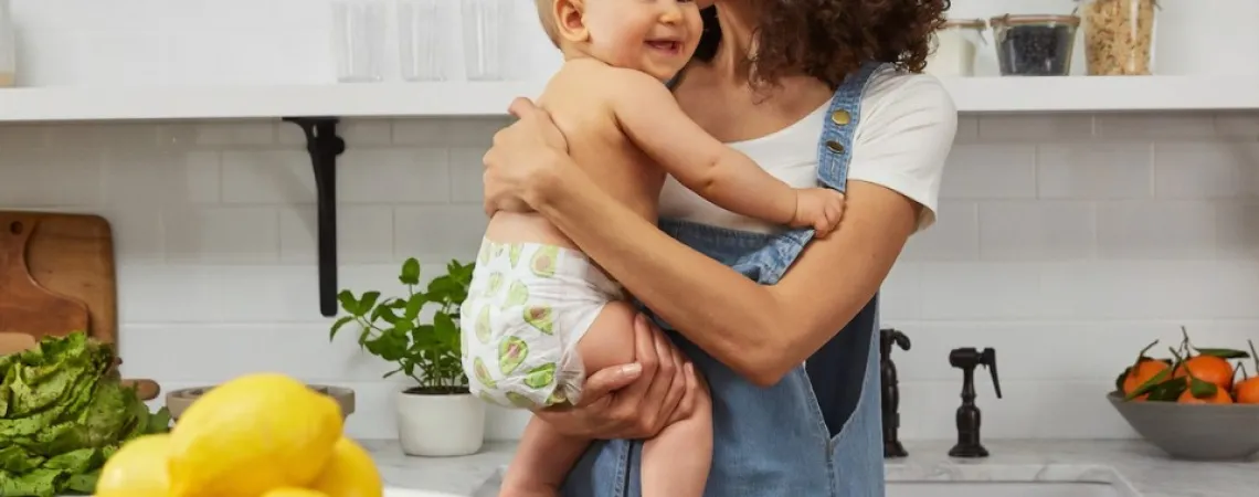 woman holding her baby in a kitchen