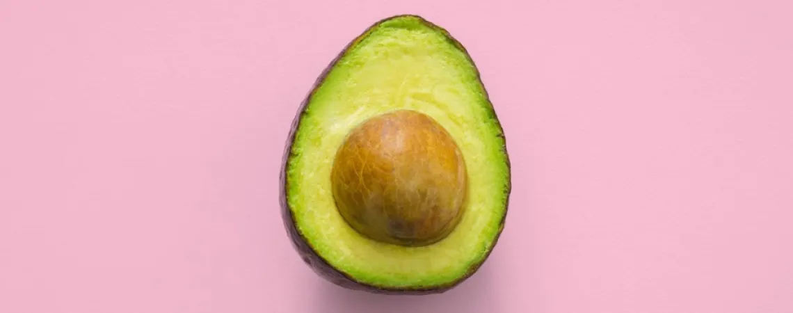 avocado in front of a pink background