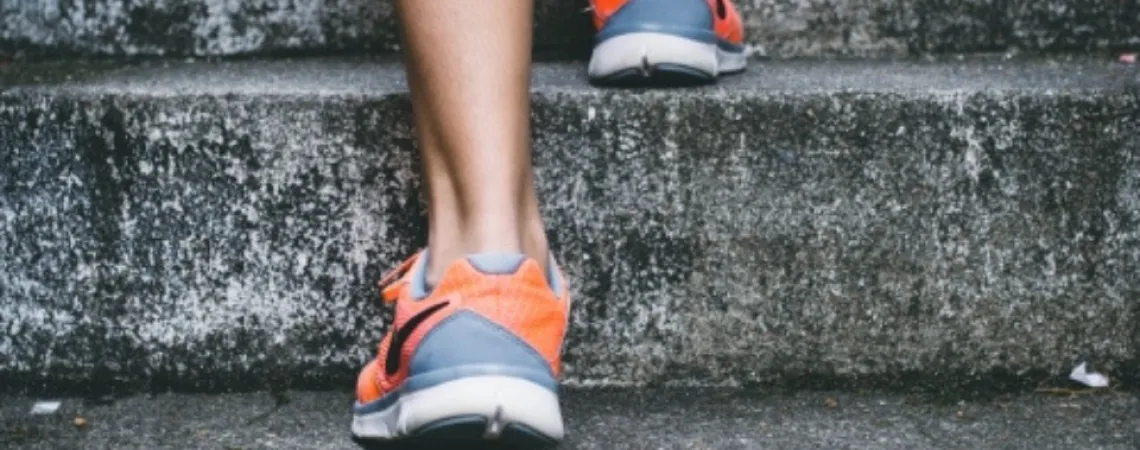a person climbing the stairs in sports shoes