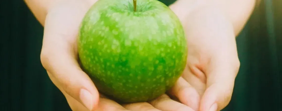 Green apple in hands