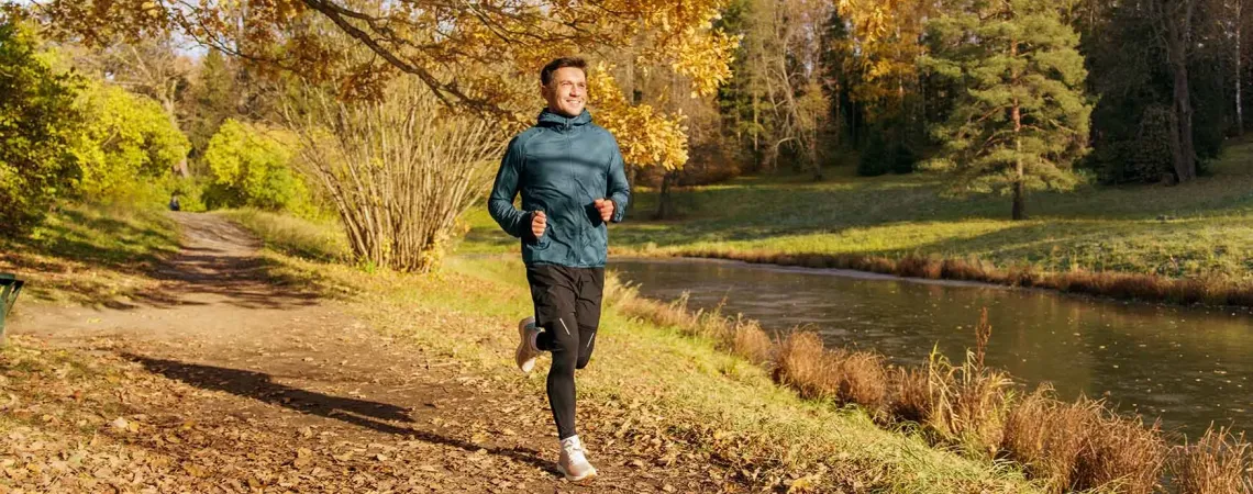 Homme courant sur un sentier d'automne - Man jogging on a leafy autumn trail