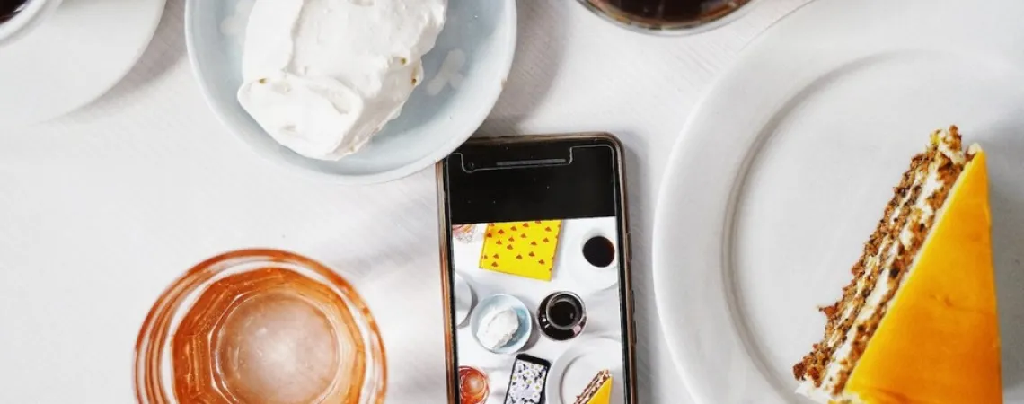 A cellphone surrounded by food and drinks