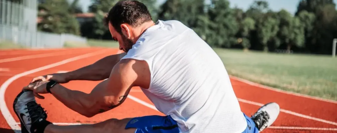 A person stretching on a racetrack